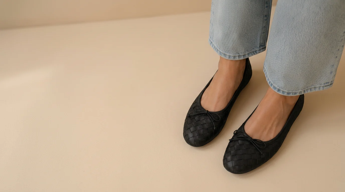 Woven black leather Chimpel ballet flats on a beige studio floor